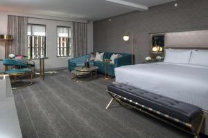 a hotel room with a bed and a couch at Tulsa Club Hotel Curio Collection By Hilton in Tulsa
