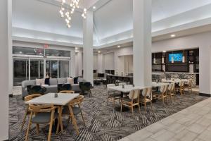 a dining room with tables and chairs and a bar at Hilton Garden Inn Birmingham SE/Liberty Park in Birmingham
