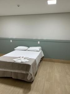 a bedroom with a bed with a tray on it at Bravo City Hotel Urupês 