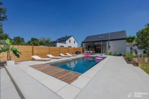 une cour avec une piscine entourée de chaises et une clôture dans l'établissement La Muse, à Chiny