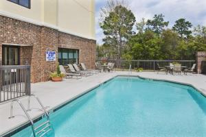 a swimming pool with chairs and tables and a building at Hampton Inn Columbia I-20-Clemson Road in Columbia