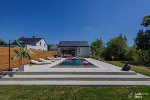 um quintal com uma piscina e uma casa em La Muse em Chiny