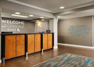 a lobby with a welcome to the grove sign on the wall at Hampton Inn Covington/Mandeville in Covington