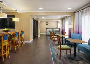 una habitación de hotel con mesas y sillas y una cocina en Hampton Inn Covington/Mandeville, en Covington