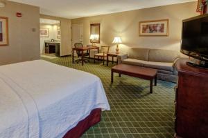 a hotel room with a bed and a couch at Hampton Inn Cambridge in Cambridge