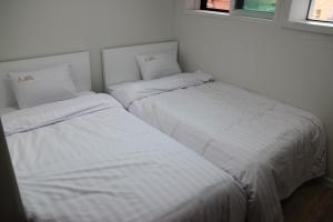 two beds sitting next to each other in a bedroom at Starhostel Dongdaemun Suite in Seoul