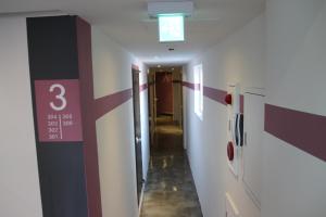 a hallway in a hospital with a clock on the wall at Starhostel Dongdaemun Suite in Seoul