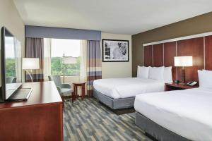 a hotel room with two beds and a desk at Doubletree By Hilton Raleigh Crabtree Valley in Raleigh +29 photos