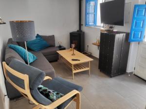 een woonkamer met een bank, een stoel en een tafel bij Casa mi sùeño azul in Torrox