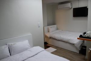 Habitación con 2 camas y TV de pantalla plana. en Starhostel Dongdaemun Suite, en Seúl