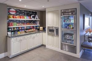 a kitchen with white cabinets and a refrigerator at Hampton Inn by Hilton San Diego - Kearny Mesa in San Diego