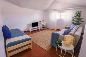uma sala de estar com um sofá e uma televisão em SandyBeachApartment em Porto Santo
