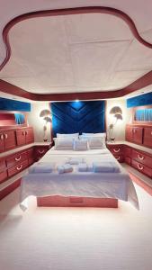 Bodrum Private Yacht Rental في بودروم: غرفة نوم بسرير ابيض كبير بجدران زرقاء