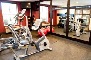 a gym with several tread machines and a mirror at Hampton Inn East Windsor in East Windsor