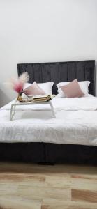 a white bed with a black headboard and pink pillows at al dorar farm 