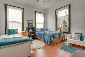 a bedroom with two beds and a chair and windows at Updated Apartment Near New York City! in East Orange