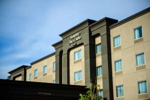 een hotel met een bord aan de zijkant van een gebouw bij Hampton Inn & Suites East Gate Regina in Regina