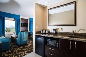 een hotelkamer met een wastafel en een woonkamer bij Hampton Inn & Suites East Gate Regina in Regina