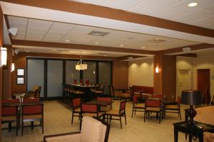 a restaurant with tables and chairs and a bar at Hampton Inn Turnersville in Blackwood