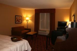 a hotel room with a bed and a chair and a television at Hampton Inn Turnersville in Blackwood
