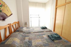 トレビエハにあるApartament Ricardo La Mataのベッドルーム1室(ベッド2台、窓付)