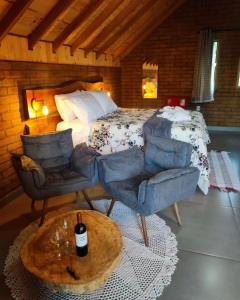 een slaapkamer met een bed en een tafel en stoelen bij Pousada das Castanheiras in Monte Verde