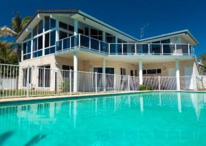 une maison avec une piscine devant dans l'établissement Beachfront Escape, à Forster