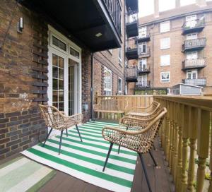 a porch with chairs and a table on a balcony at Cozy flat near Kings Cross in London