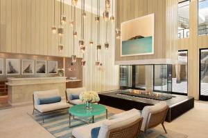 Oceana Santa Monica, LXR Hotels & Resorts في لوس أنجلوس: غرفة معيشة فيها موقد وثريا