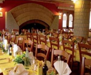 a dining room with tables and chairs in a restaurant at Hotel La Baita in Malborghetto Valbruna