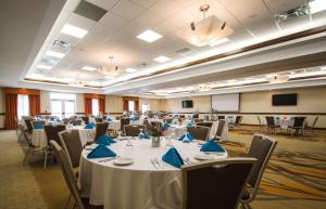 einen großen Bankettsaal mit Tischen und Stühlen mit blauen Servietten in der Unterkunft Hilton Garden Inn Watertown in Watertown
