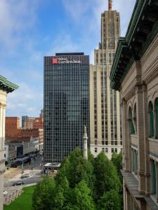 een hoog gebouw met een bord erop in een stad bij The Hilton Garden Inn Buffalo-Downtown in Buffalo