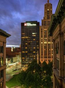 een hoog gebouw met een bord erop in een stad bij The Hilton Garden Inn Buffalo-Downtown in Buffalo