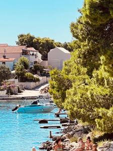 a group of people swimming in a body of water at Modern Seafront Villa Steps from the Beach in Rogoznica