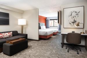 Habitación de hotel con sofá, cama y escritorio. en SpringHill Suites by Marriott Dallas Downtown / West End, en Dallas