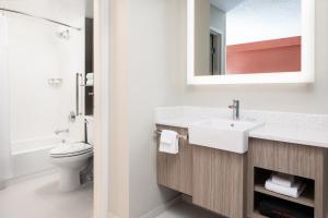 a bathroom with a sink and a toilet and a mirror at SpringHill Suites by Marriott Dallas Downtown / West End in Dallas
