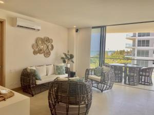 d'un salon avec un canapé et des chaises ainsi que d'un balcon. dans l'établissement Apartamento de Lujo Morros Zóe - Manzanillo - Cartagena, à Carthagène des Indes