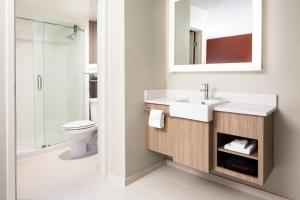 a bathroom with a sink and a toilet and a mirror at SpringHill Suites by Marriott Dallas Downtown / West End in Dallas