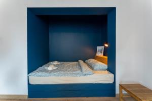 a bedroom with a blue wall with a bed in it at Apartament Wolności Lubomierz in Lubomierz