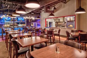 un ristorante con tavoli e sedie in legno e un bar di Hilton Garden Inn Little Rock Downtown a Little Rock