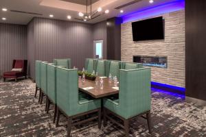 小石城Hilton Garden Inn Little Rock Downtown的一间会议室,配有桌子和绿色椅子