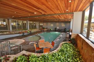 a pool in a building with a table and chairs at Doubletree by Hilton McAllen in McAllen