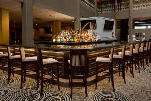 un bar con un mucchio di sgabelli da bar in un ristorante di Doubletree by Hilton McAllen a McAllen