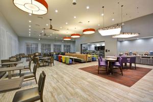 um restaurante com mesas e cadeiras e uma cafetaria em Homewood Suites by Hilton Orlando Theme Parks em Orlando