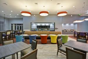 a restaurant with tables and chairs and a bar at Homewood Suites by Hilton Orlando Theme Parks in Orlando