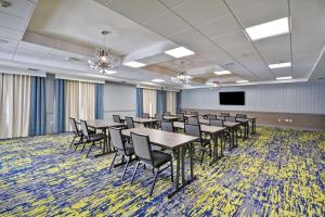 a conference room with tables and chairs and a screen at Homewood Suites by Hilton Orlando Theme Parks in Orlando