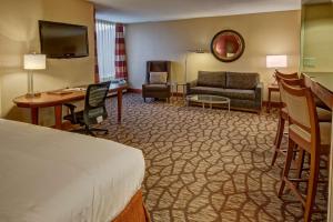 um quarto de hotel com uma cama e uma sala de estar em DoubleTree by Hilton Hotel Oak Ridge - Knoxville em Oak Ridge