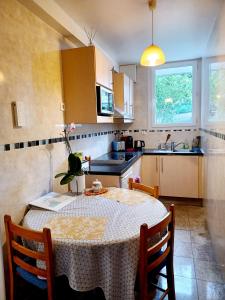eine Küche mit einem Tisch und einem Tischtuch darauf in der Unterkunft 3 private rooms shared flat in a villa at Sceaux 600m RER B direct to Notre-Dame in Sceaux