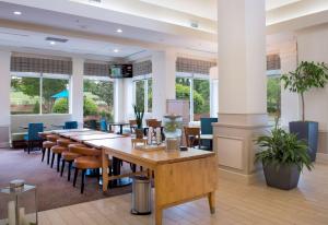 un comedor con mesas, sillas y ventanas en Hilton Garden Inn Rock Hill, en Rock Hill