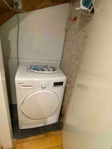 uma máquina de lavar e secar roupa num canto de um quarto em Elegant flat in a fantastic area em Londres